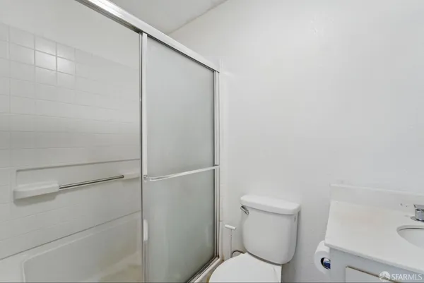 a white toilet sitting next to a shower
