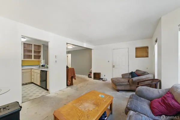 a living room with furniture and kitchen view
