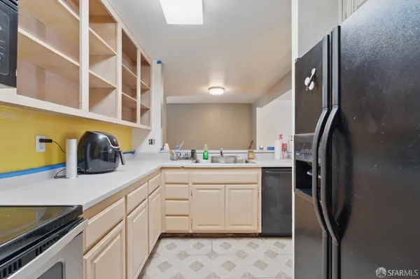 a kitchen with a sink refrigerator and cabinets