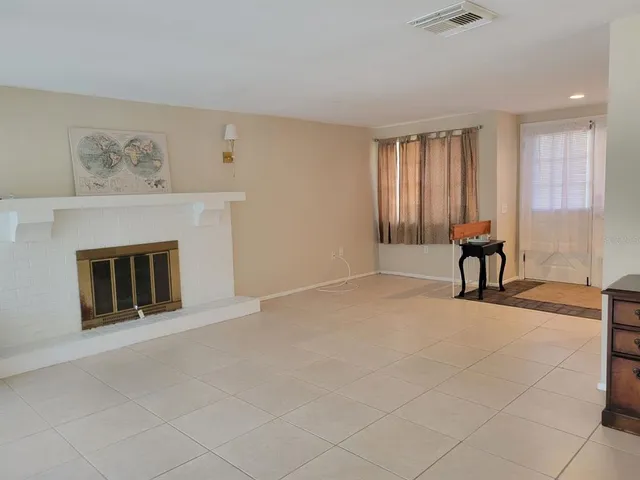 a view of an empty room with window and fireplace