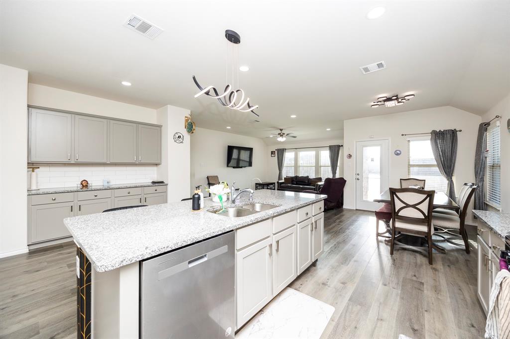 3229 Trails End Road Aubrey, TX 76227 - Photo 24 of 25 Kitchen featuring decorative light fixtures, stainless steel dishwasher, recessed lighting, light stone counters, and open floor plan