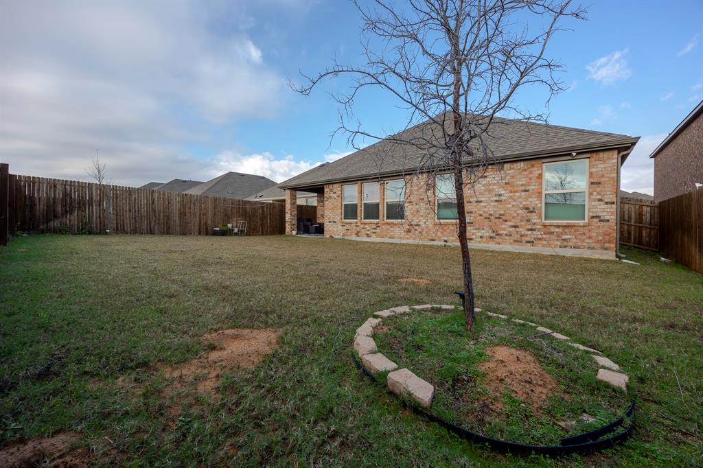 3229 Trails End Road Aubrey, TX 76227 - Photo 20 of 25 Back of house with roof with shingles, a patio, a fenced backyard, and brick siding