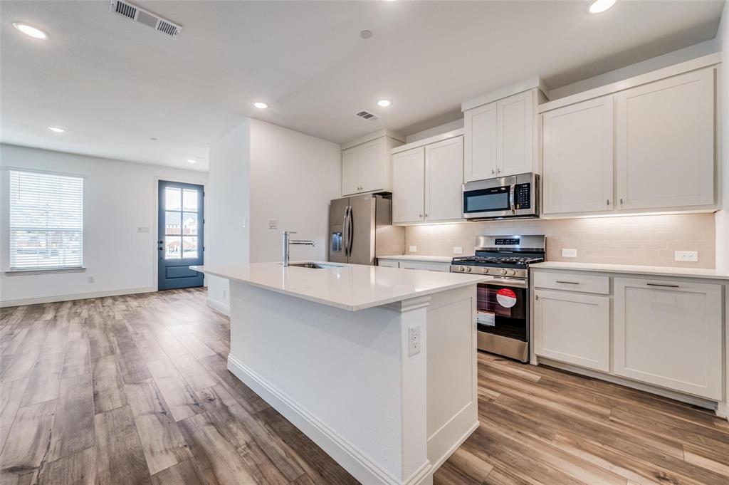 8940 Samara Street Frisco, TX 75035 - Photo 1 of 28 a kitchen with kitchen island granite countertop a sink cabinets and stainless steel appliances