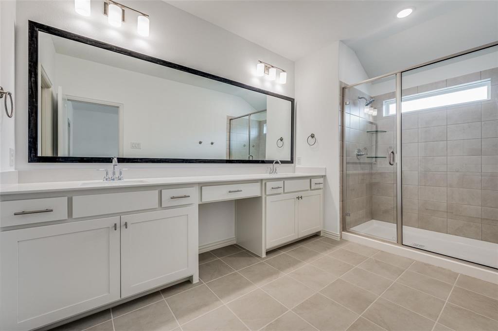 8940 Samara Street Frisco, TX 75035 - Photo 16 of 28 a bathroom with a sink a mirror and a shower