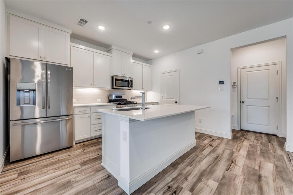 8940 Samara Street Frisco, TX 75035 - Photo 4 of 28 a kitchen with stainless steel appliances a refrigerator sink and microwave