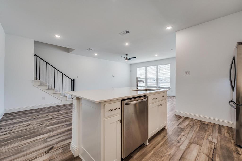 8940 Samara Street Frisco, TX 75035 - Photo 6 of 28 a view of a kitchen with a sink and dishwasher with wooden floor