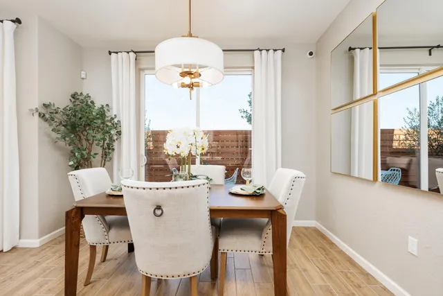 a view of a dining room with furniture a chandelier and wooden floor