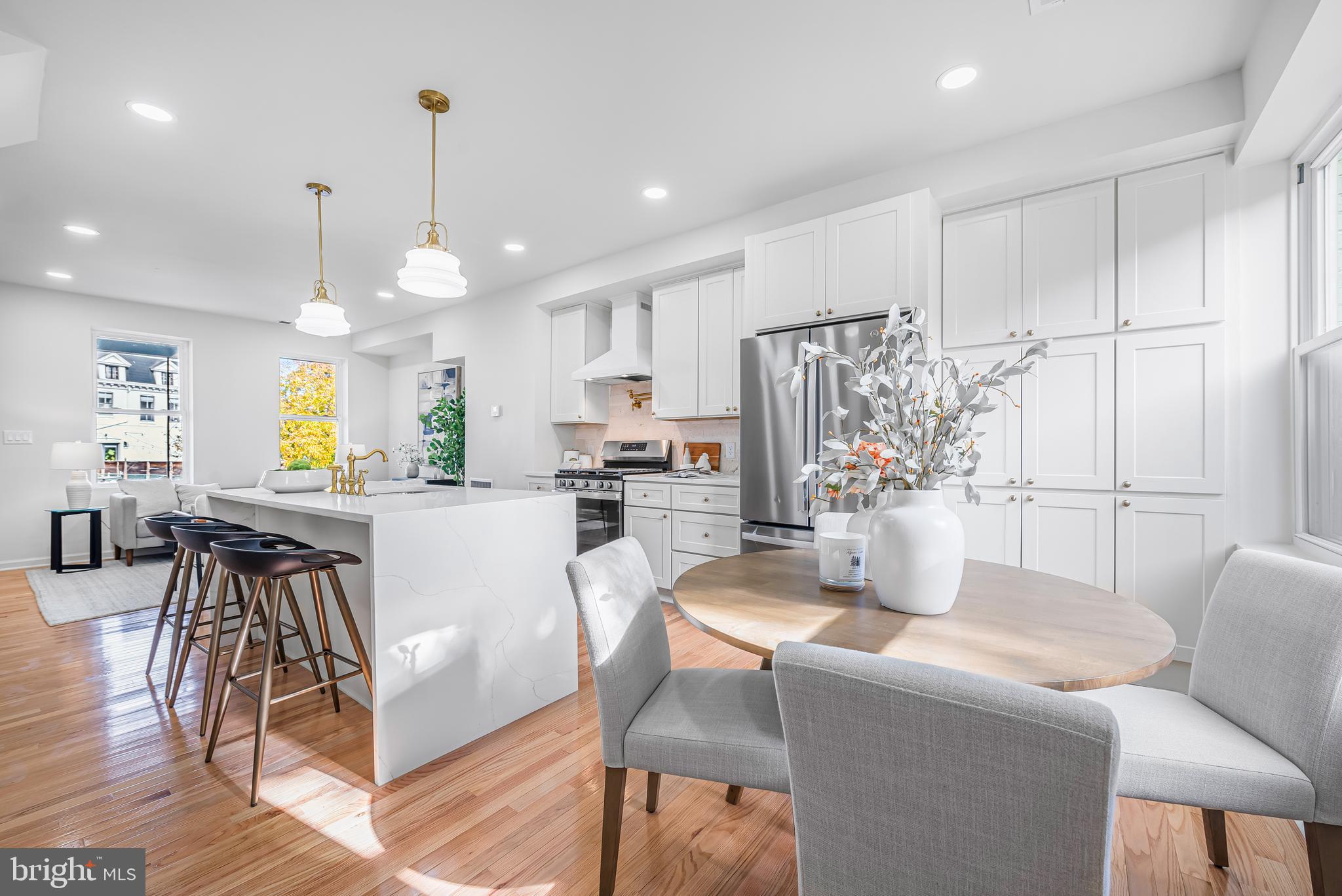 177 V Street Northeast Washington, DC 20002 - Photo 14 of 32 a kitchen with stainless steel appliances granite countertop a refrigerator a microwave oven a dining table and chairs with wooden floor