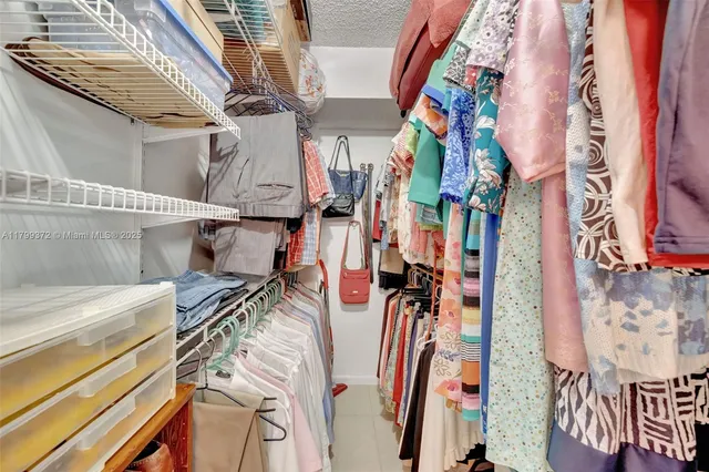 a view of walk in closet with clothes