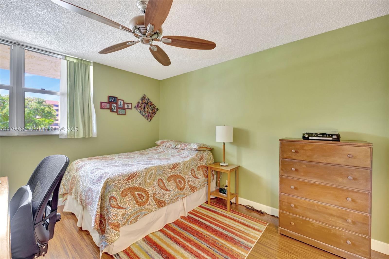7080 Environ Boulevard, Unit 223 Lauderhill, FL 33319 - Photo 18 of 36 a bedroom with a bed and a chandelier