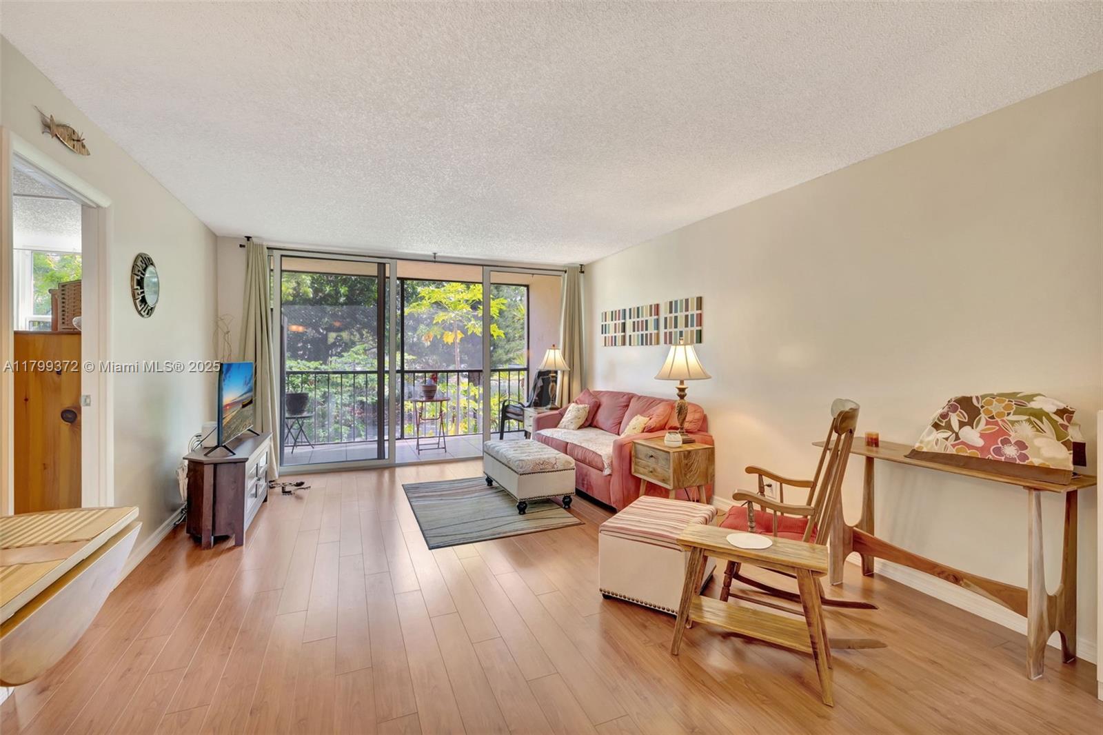 7080 Environ Boulevard, Unit 223 Lauderhill, FL 33319 - Photo 7 of 36 a living room with furniture and a large window