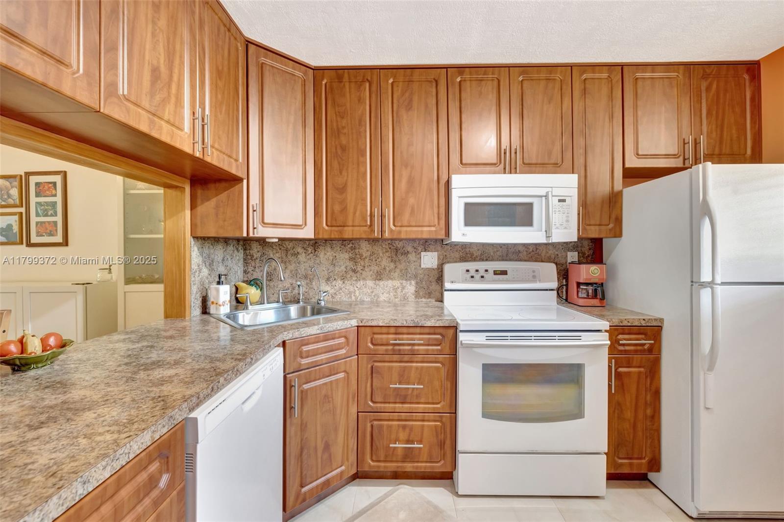 7080 Environ Boulevard, Unit 223 Lauderhill, FL 33319 - Photo 9 of 36 a kitchen with a stove top oven sink and cabinets