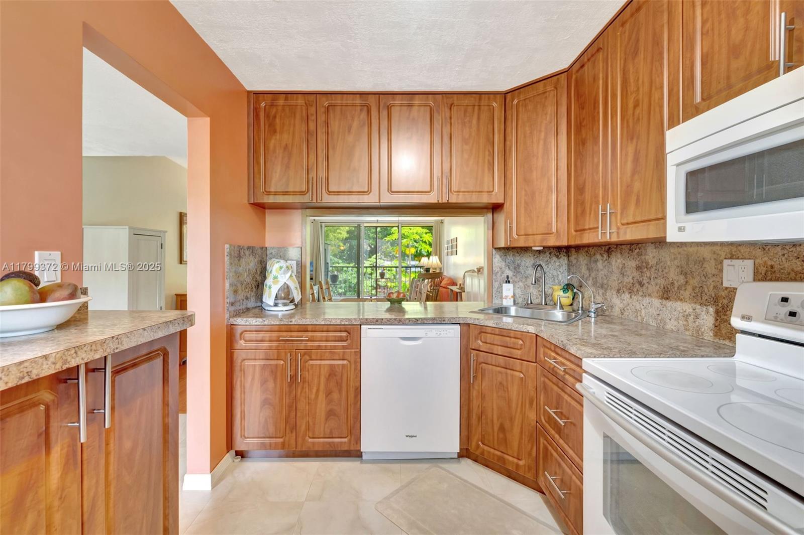 7080 Environ Boulevard, Unit 223 Lauderhill, FL 33319 - Photo 10 of 36 a kitchen with a sink cabinets stainless steel appliances and a window