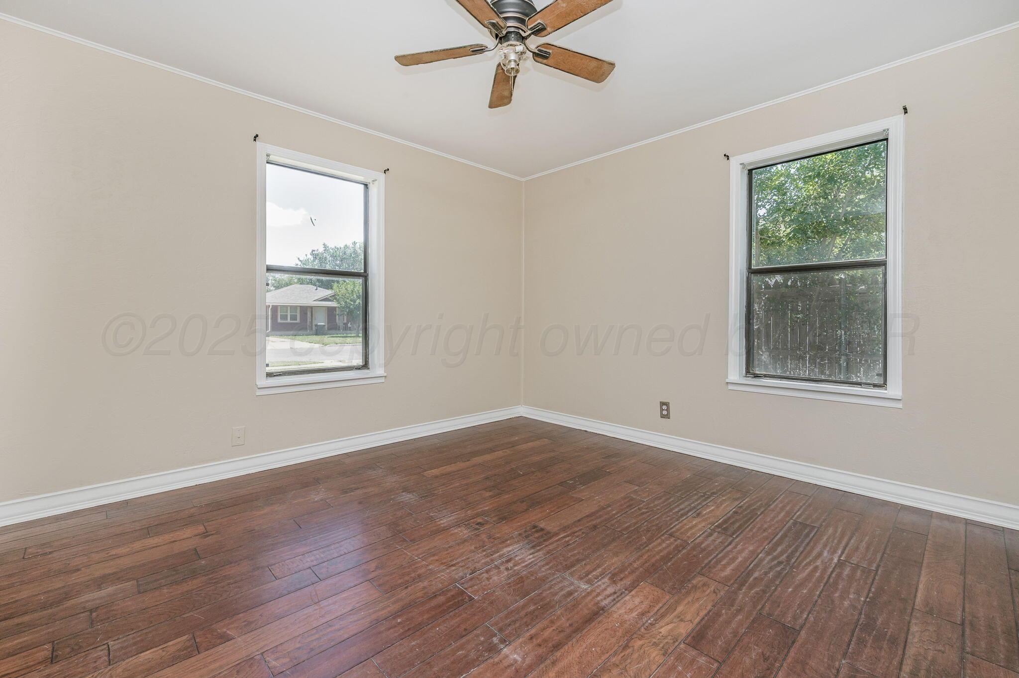 4004 South Van Buren Street Amarillo, TX 79110 - Photo 12 of 17 a view of an empty room with wooden floor and a window