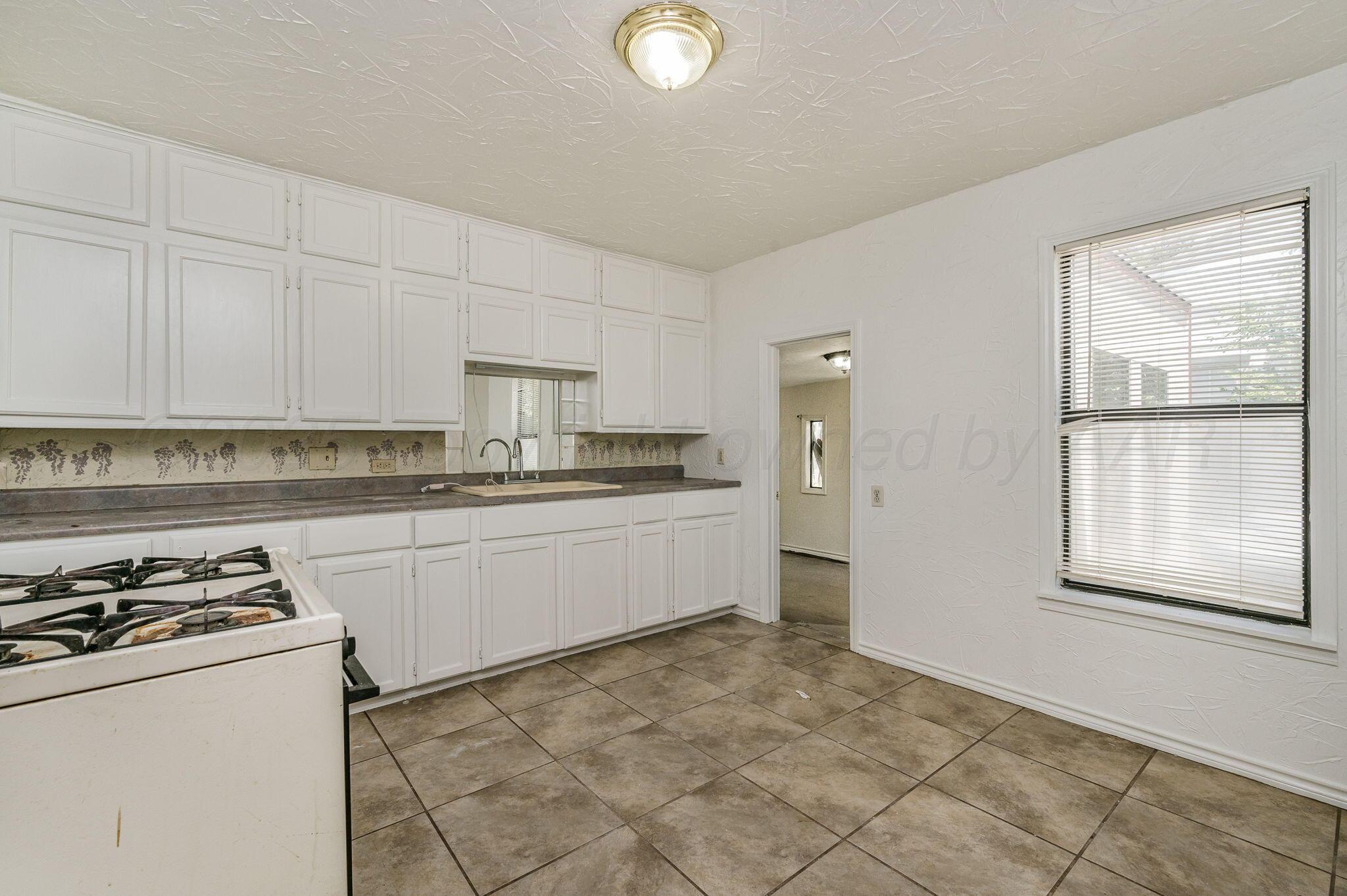 4004 South Van Buren Street Amarillo, TX 79110 - Photo 4 of 17 a kitchen with stainless steel appliances granite countertop a stove a sink and a refrigerator