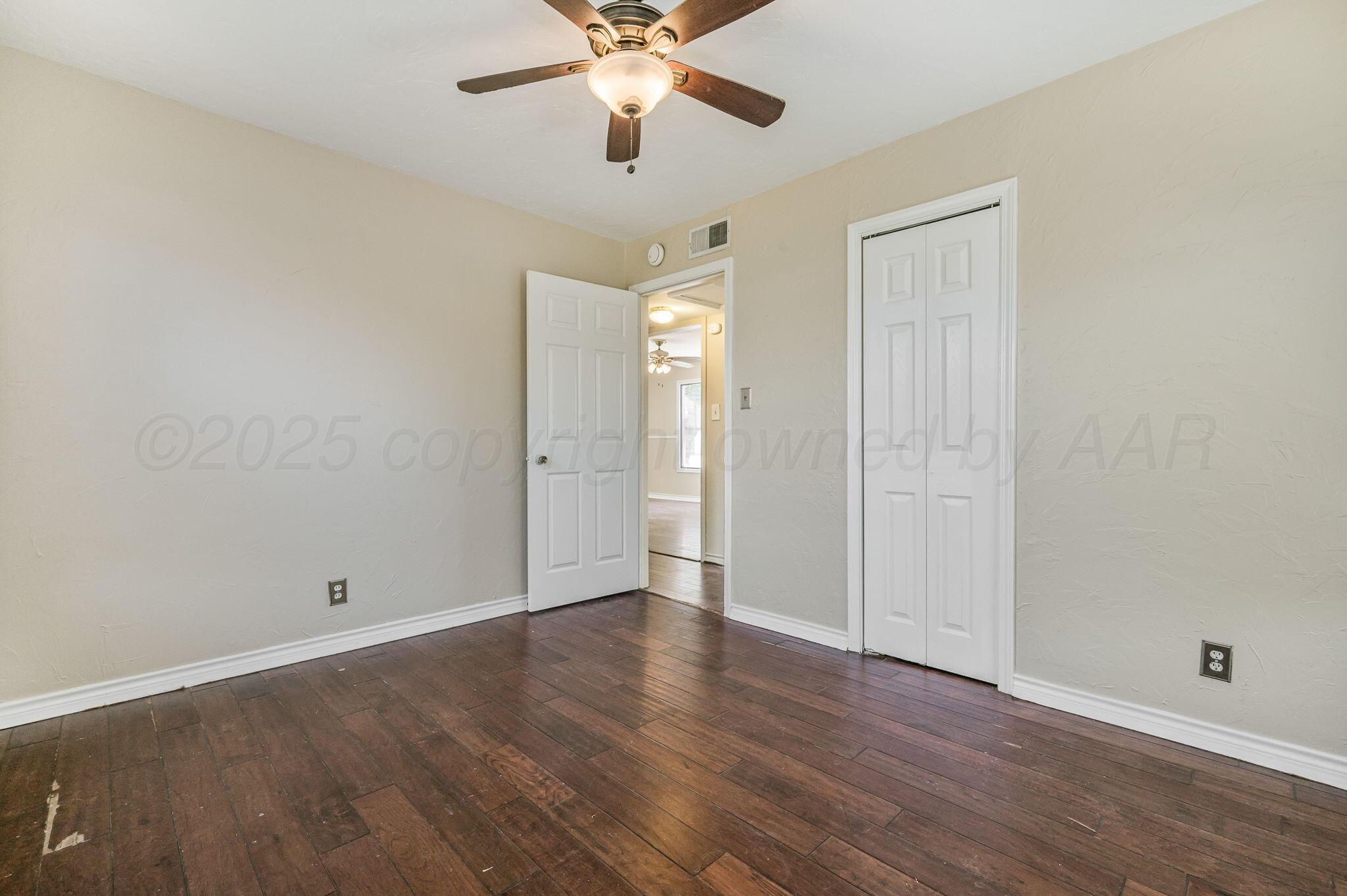 4004 South Van Buren Street Amarillo, TX 79110 - Photo 7 of 17 wooden floor in an empty room with a window