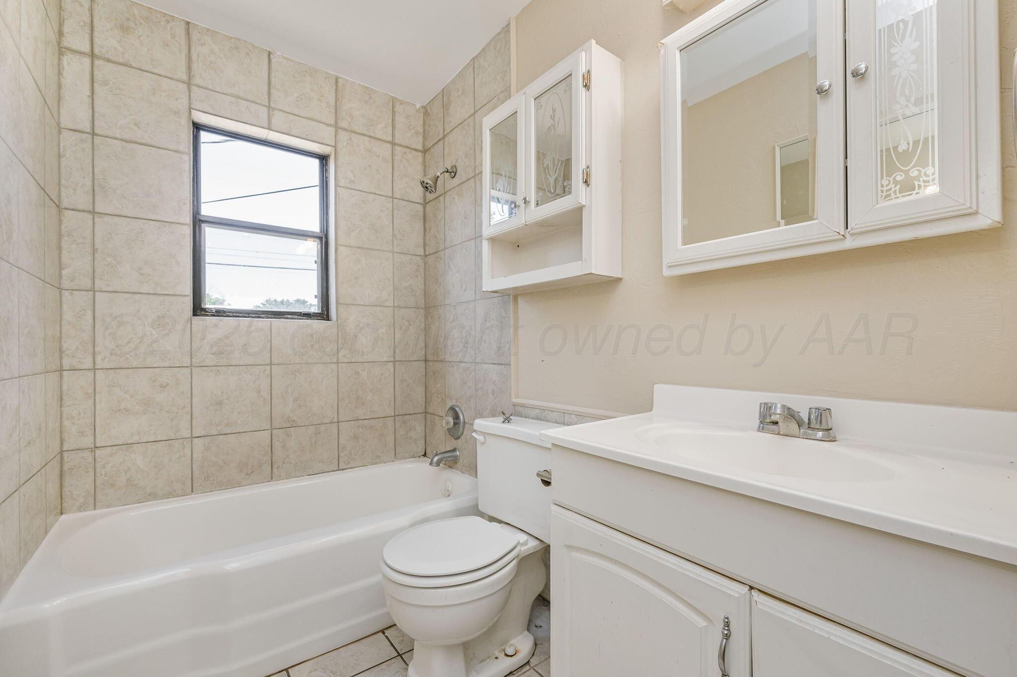 4004 South Van Buren Street Amarillo, TX 79110 - Photo 8 of 17 a bathroom with a sink a toilet and bathtub