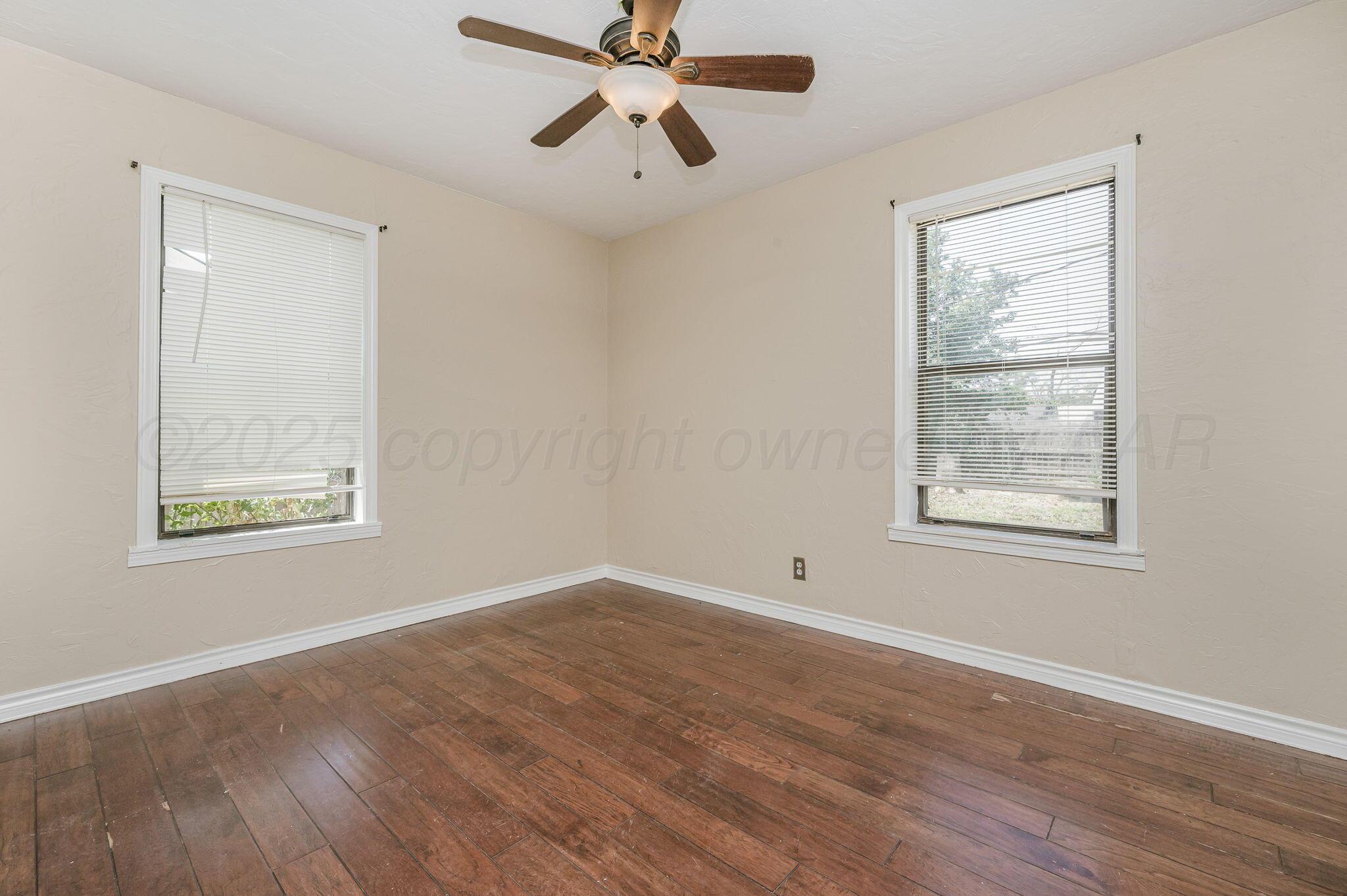 4004 South Van Buren Street Amarillo, TX 79110 - Photo 10 of 17 a view of an empty room with wooden floor and a window