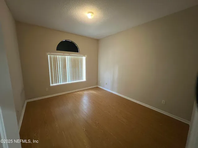 an empty room with a kitchen and a window