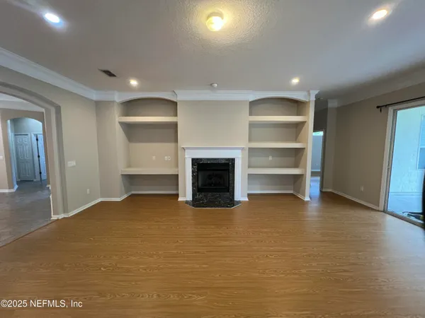 a view of an empty room with a fireplace and a window