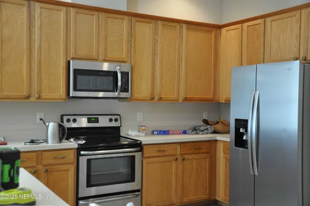 a kitchen with stainless steel appliances granite countertop a refrigerator stove top oven and sink