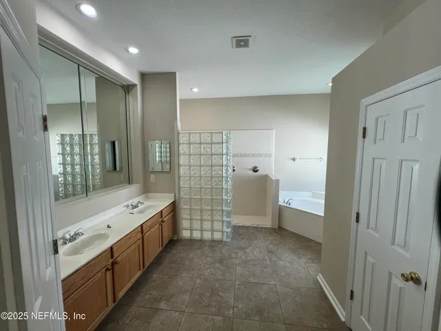 a bathroom with a glass door shower a sink and a mirror