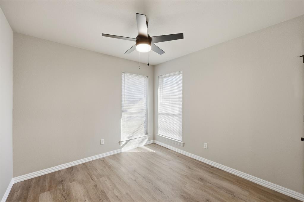 8875 Fm 2450 Sanger, TX 76266 - Photo 15 of 28 an empty room with wooden floor ceiling fan and window