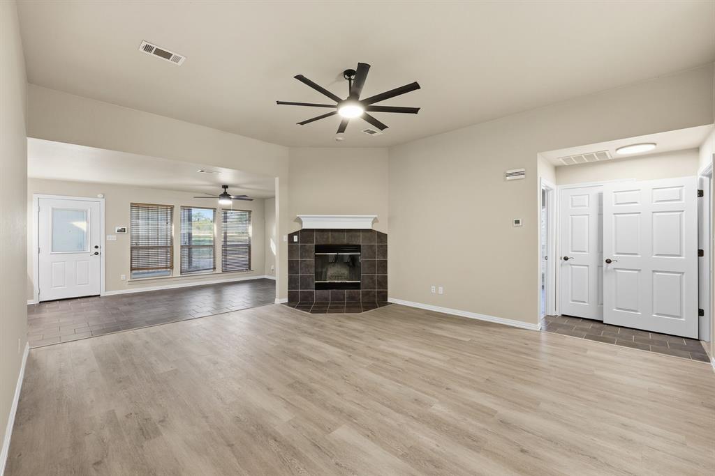 8875 Fm 2450 Sanger, TX 76266 - Photo 6 of 28 an empty room with wooden floor chandelier fan and windows
