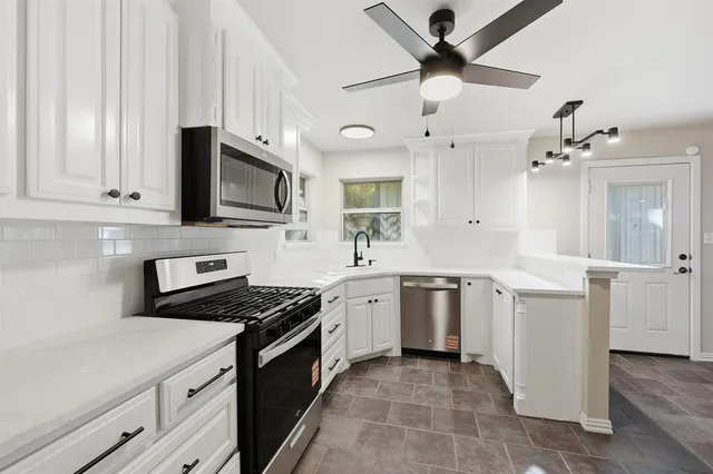 a kitchen with stainless steel appliances a stove sink and cabinets