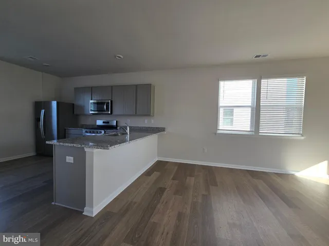 a kitchen with wooden floors and white appliances
