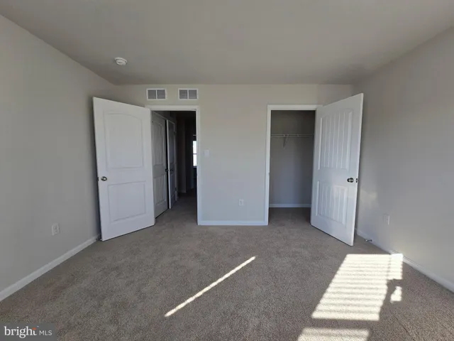 an empty room with a window and a hallway