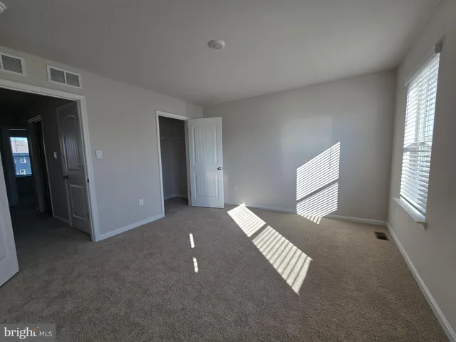 a view of an empty room with windows and a ceiling fan