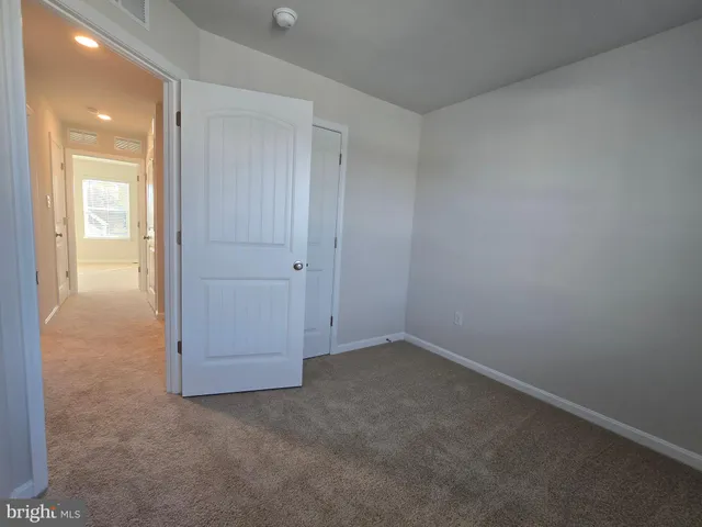 an empty room with closet and windows