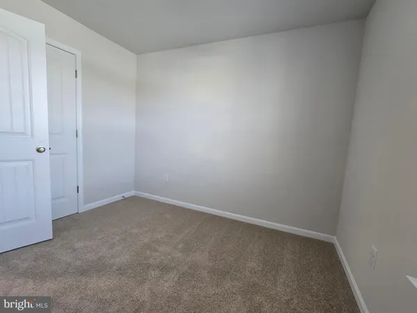 a view of a hallway with bathroom and sink