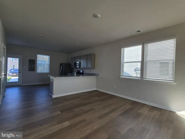 a view of a living room a window and wooden floor