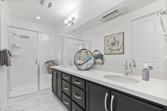 a bathroom with a granite countertop sink a mirror and shower