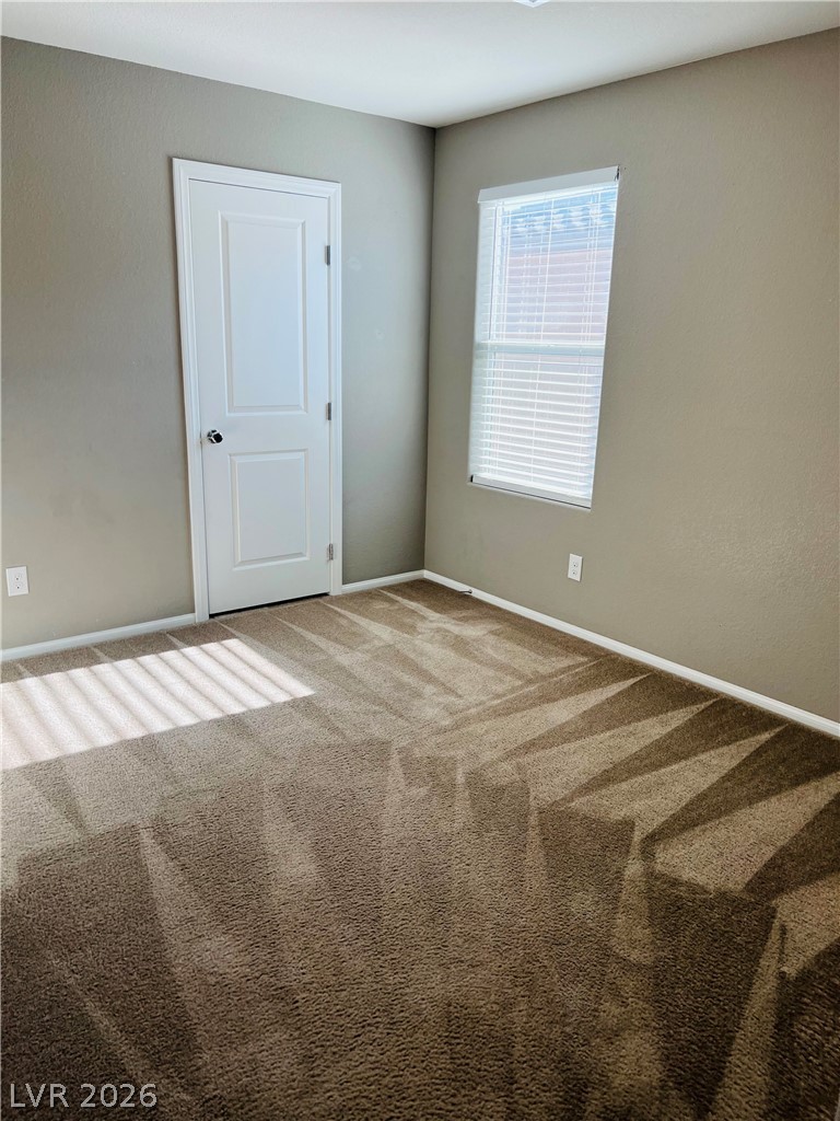 9325 Keystone Ridge Avenue Las Vegas, NV 89148 - Photo 11 of 17 A well-lit bedroom space features soft carpeting and a window offering natural light.
