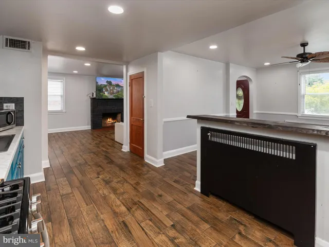 a kitchen with kitchen island sink and wooden floor
