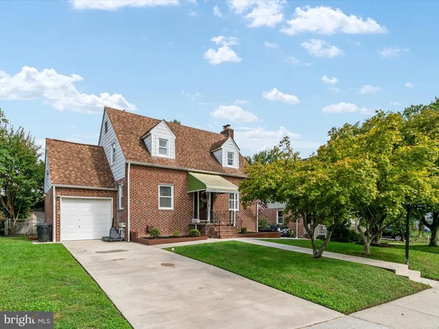 a front view of a house with a garden and trees
