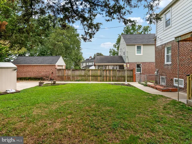a front view of a house with yard and a tree