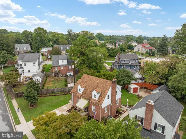 an aerial view of residential houses with outdoor space and trees