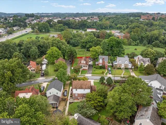 an aerial view of residential houses with outdoor space and trees
