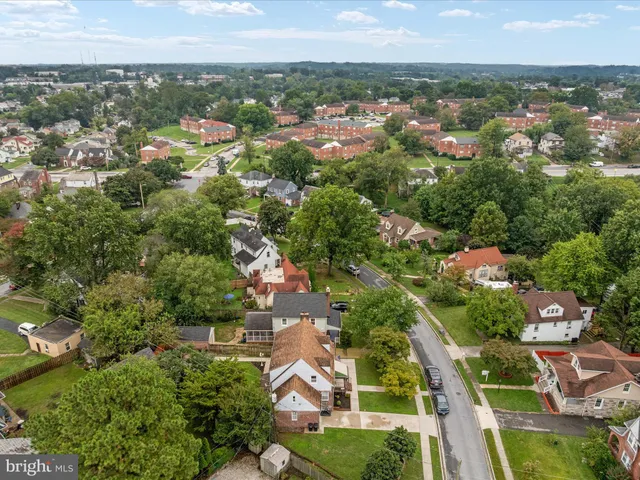 an aerial view of residential houses with outdoor space and trees