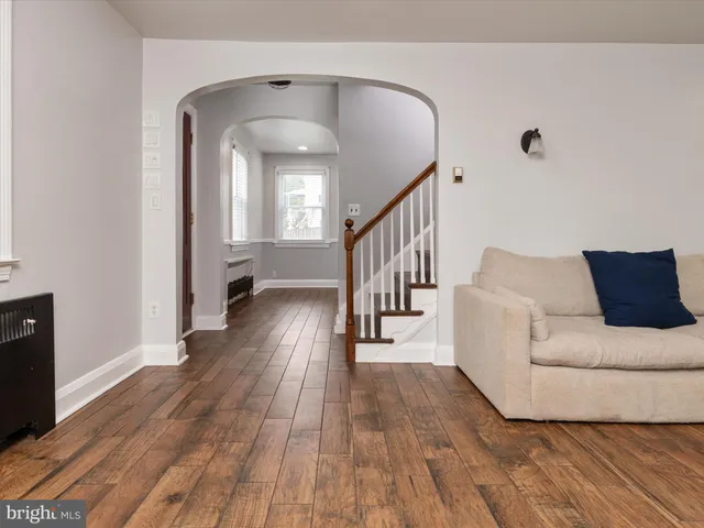 a living room with wooden floor and a rug