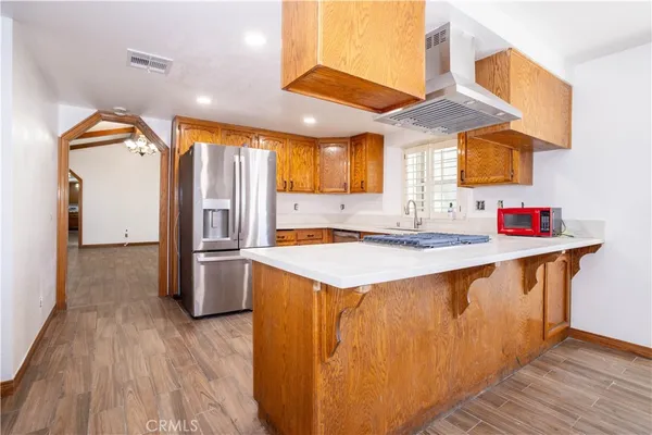 a kitchen with stainless steel appliances granite countertop a sink and a refrigerator