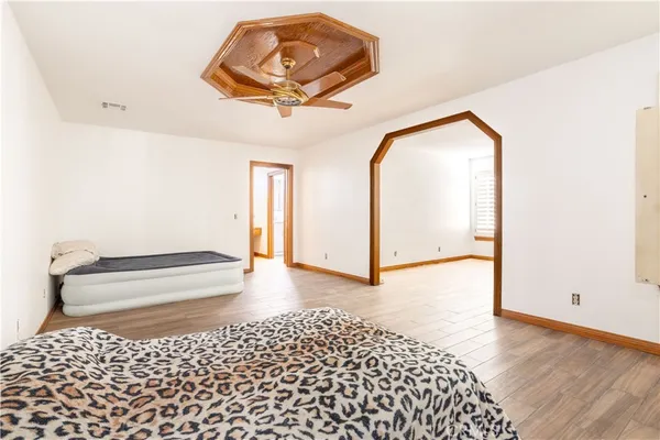 a bedroom with a bed and a painting on the wall