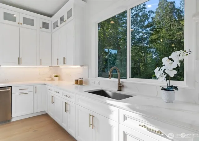 a kitchen that has a sink a stove and a window