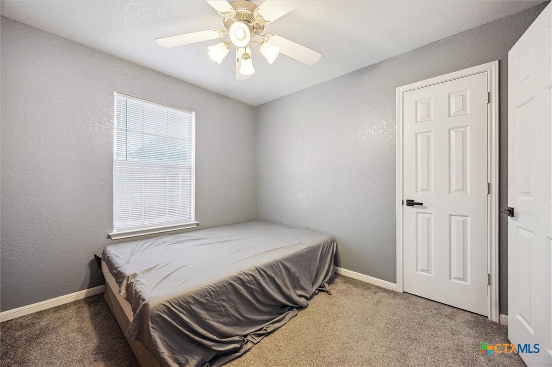1220 Redstone Drive Temple, TX 76502 - Photo 21 of 35 a bedroom with a bed and a chandelier