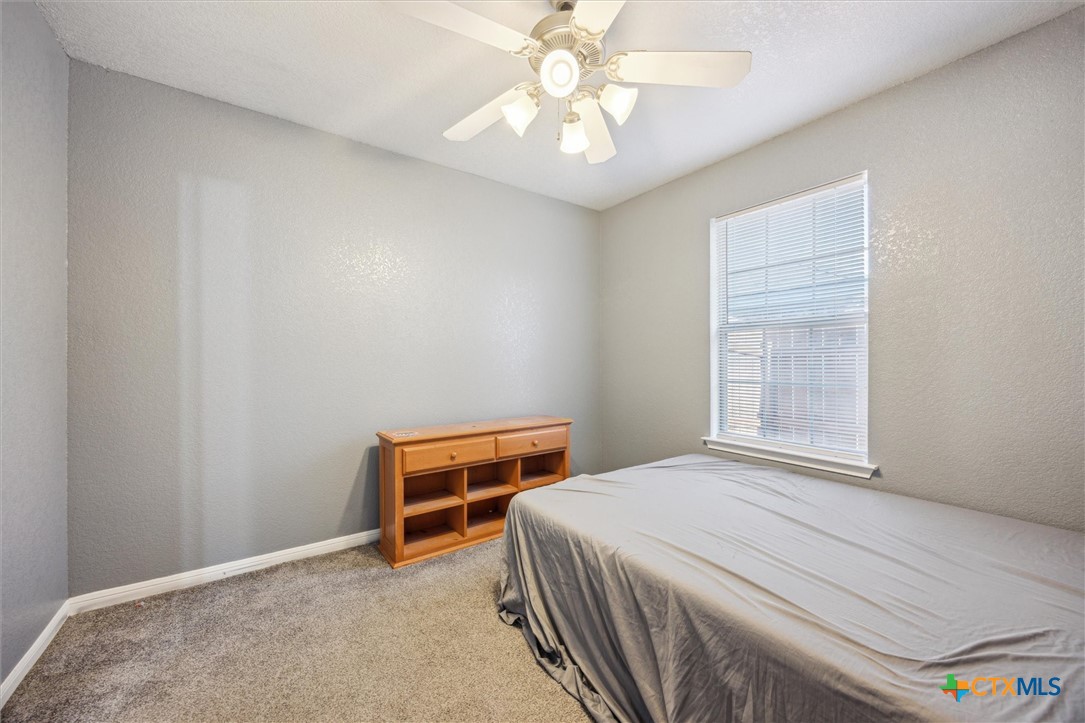 1220 Redstone Drive Temple, TX 76502 - Photo 22 of 35 a bedroom with a bed and a chandelier
