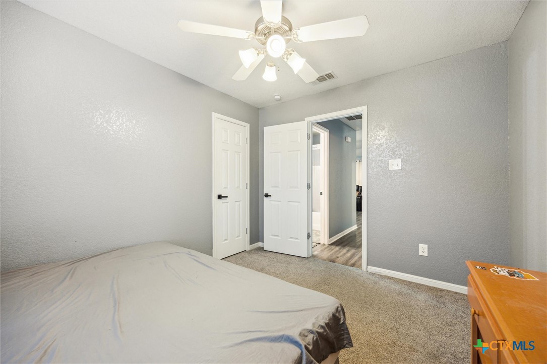 1220 Redstone Drive Temple, TX 76502 - Photo 23 of 35 a spacious bedroom with a bed and a chandelier